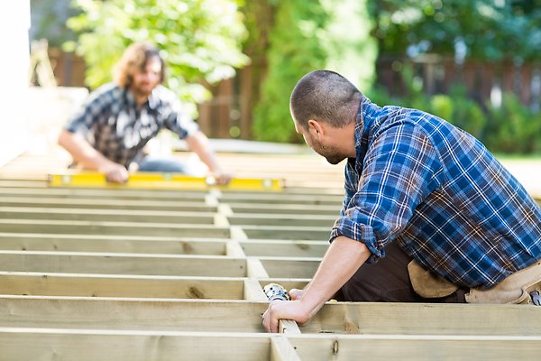 Två män hjälps åt att bygga en altan.